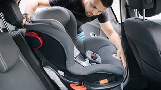 silla de coche de segunda mano- hombre instalando un asiento de seguridad infantil
